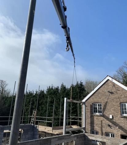 A crane lifts materials in a house build